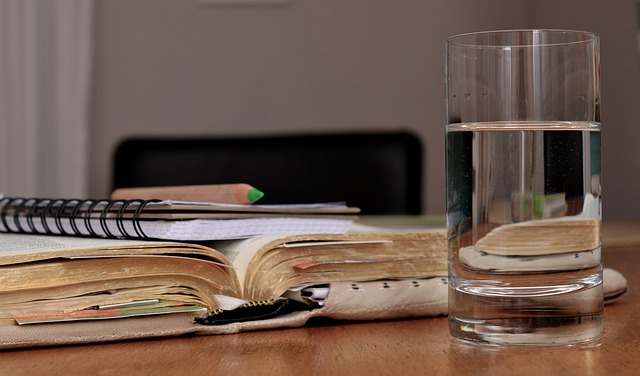 Placeholder image of open book, notepad and glass of water.